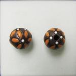 Orange leaves on dark clay round bead